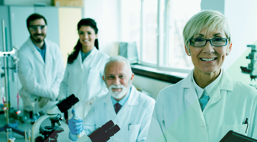 Four people smile out of the screen from their lab stations.